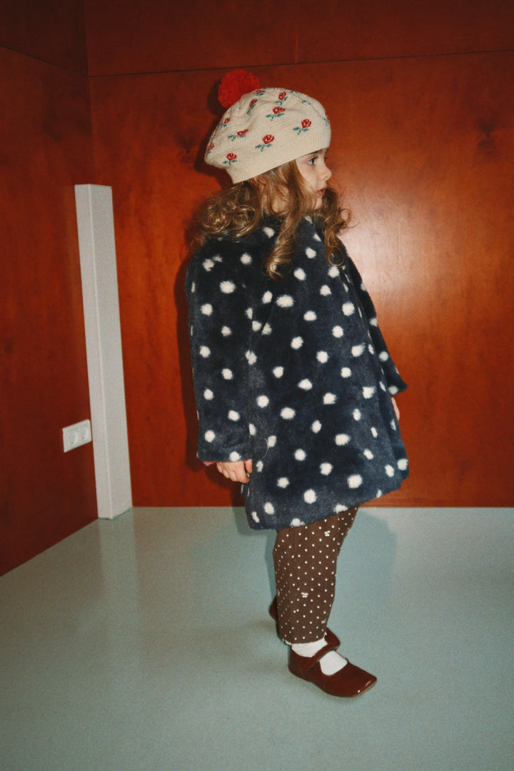 Barn i Belou-baskern med prickig jacka, från sidan